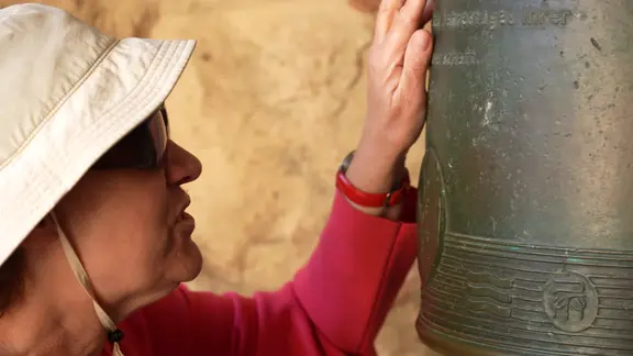 Eine sehbehinderte Frau erstastet mit ihren Finger eine Schrift auf einer Glocke | NDR Eine sehbehinderte Frau erstastet mit ihren Finger eine Schrift auf einer Glocke