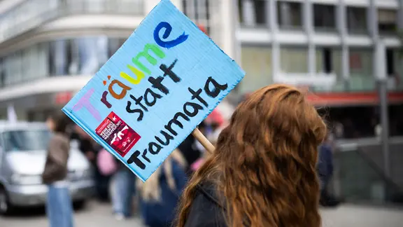 Hannover: Eine Teilnehmerin steht mit einem Plakat "Träume statt Traumata" bei einer Demonstration "Schulstreik gegen Wehrpflicht" in der Innenstadt. | dpa-Bildfunk, Julian Stratenschulte Hannover: Eine Teilnehmerin steht mit einem Plakat "Träume statt Traumata" bei einer Demonstration "Schulstreik gegen Wehrpflicht" in der Innenstadt.