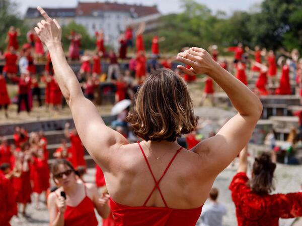 Fans of English singer Kate Bush perform a dance during a flash mob event to mark 'The Most Wuthering Heights Day Ever' in Goerlitzer Park in Berlin on July 18, 2026. Kate Bush fans put on their best billowy red dresses and danced en masse in Berlin on July 18, to one of the singer's most iconic songs Wuthering Heights in a flashmob event being held around the world. (Photo by David GANNON / AFP)