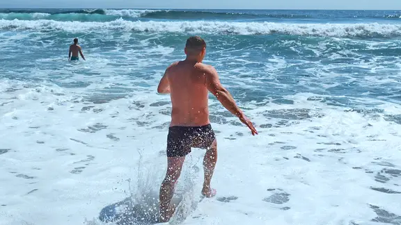 Ein Mann läuft am Meer in die Brandung | Colourbox, Media Whale Stock Ein Mann läuft am Meer in die Brandung