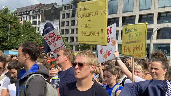 Demonstrierende halten Schilder hoch.