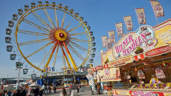 Besucher gehen über den Hamburger Dom auf dem Heiligengeistfeld. | picture alliance / dpa, Georg Wendt Besucher gehen über den Hamburger Dom auf dem Heiligengeistfeld.
