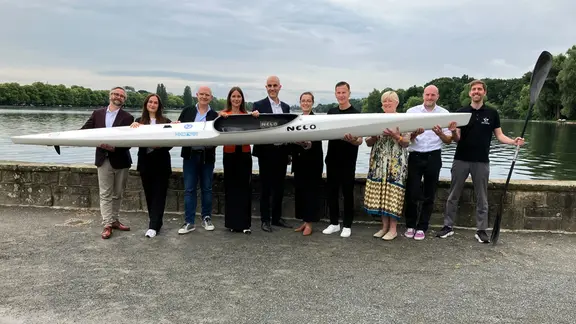 Eine Gruppe hält vor dem Maschsee in Hannover ein Kayak in die Kamera. | Simon Schmidt/NDR Eine Gruppe hält vor dem Maschsee in Hannover ein Kayak in die Kamera.
