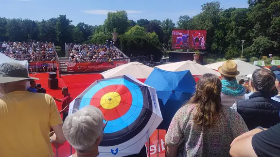 Beim Bogenschießen schützen sich die Zuschauer mit Schirmen vor der Hitze - mit Motiven passend zum Sport. | NDR, Kristin Häfemeier Beim Bogenschießen bei den Finals in Hannover schauen viele Menschen zu.
