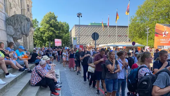 Vor dem Neuen Rathaus stehen viele Besucher für die Wettbewerbe im Breaking an. | NDR, Tiede Thedinga Vor dem Neuen Rathaus in Hannover stehen viele Menschen für die Finals an.