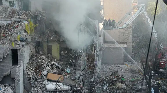 Rettungskräfte sind nach einem russischen Angriff in Kiew mit der Brandbekämpfung beschäftigt. | picture alliance/dpa/AP | Efrem Lukatsky Angriffe auf Kiew