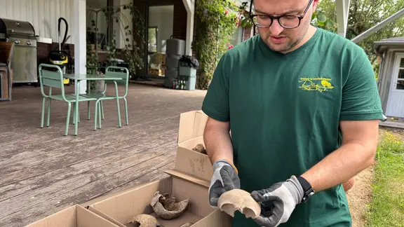 Auch einen Schädel hat Felix Chall in seinem Garten gefunden. | NDR, Sabine Hausherr Mann hält einen Knochen in der Hand.