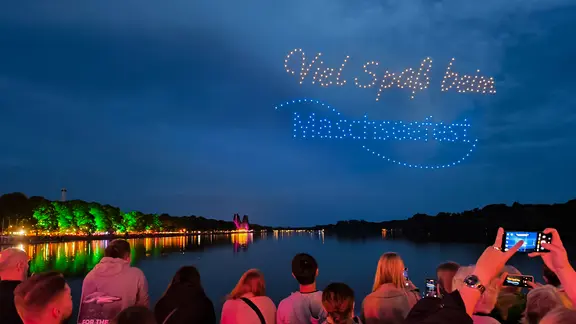 Beim Maschseefest schreiben Drohnen "Viel Spaß beim Maschseefest!" in den Abendhimmel. | NDR, Yannic Wittenberg Beim Maschseefest schreiben Drohnen "Viel Spaß beim Maschseefest!" in den Abendhimmel.