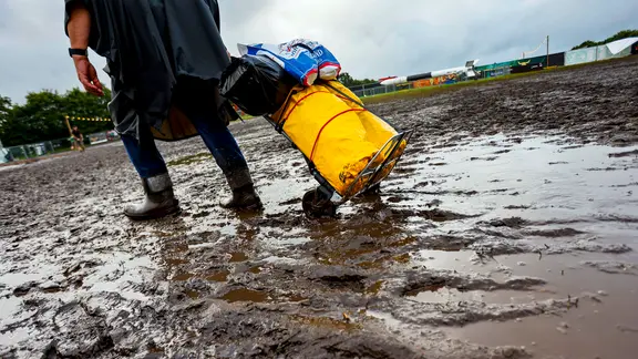 Ein Festival-Besucher schleppt sein Gepäck durch den Matsch von Wacken | Frank Molter/dpa Ein Festival-Besucher schleppt sein Gepäck durch den Matsch von Wacken