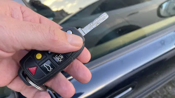 Fernbedienung eines Autos in einer Hand an einer Autotür | Peter Schmidt, Peter Schmidt Fernbedienung eines Autos in einer Hand an einer Autotür