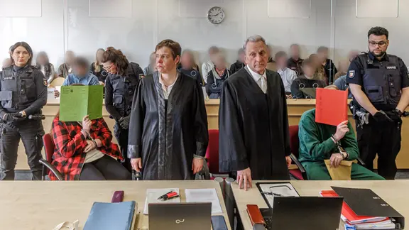 Die wegen Mordes an einem Säugling angeklagten Eltern verbergen im Gerichtssaal ihre Gesichter. | picture alliance/dpa | Markus Scholz Die wegen Mordes an einem Säugling angeklagten Eltern verbergen im Gerichtssaal ihre Gesichter.