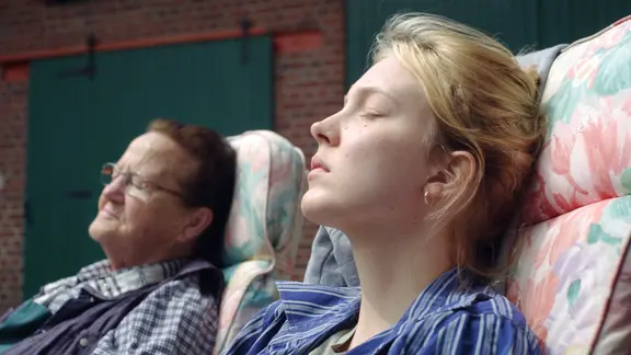 Filmszene aus "Sechswochenamt": Zwei Frauen sitzen in draußen in Gartenstühlen und halten das Gesicht in die Sonne. | Filmweh, Markus Ott Filmszene aus "Sechswochenamt": Zwei Frauen sitzen in draußen in Gartenstühlen und halten das Gesicht in die Sonne.