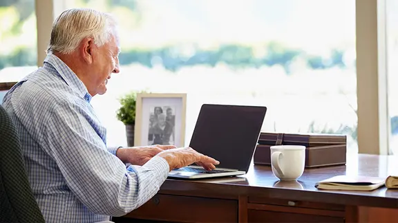 Ein Senior sitzt am Schreibtisch vor einem Laptop | Fotolia.com, Monkey Business Ein Senior sitzt am Schreibtisch vor einem Laptop