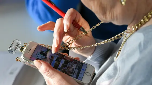 Eine Seniorin schaut auf ihr Smartphone. | picture alliance/dpa/dpa-Zentralbild | Jens Kalaene Eine Seniorin schaut auf ihr Smartphone.