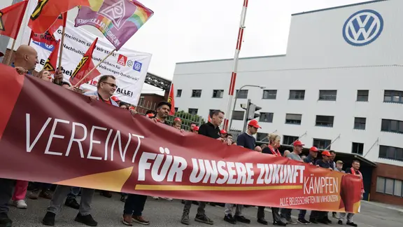 Mitarbeitende von Volkswagen beteiligen sich an einer Informations- und Protestaktion der IG Metall vor dem VW-Werk in Osnabrück. | dpa, David Ebener Mitarbeitende von Volkswagen beteiligen sich an einer Informations- und Protestaktion der IG Metall vor dem VW-Werk in Osnabrück.
