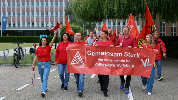 Vor der Aufsichtsratssitzung kommt es in Wolfsburg zu einer Protestaktion. | dpa, Lisi Niesner Mitarbeitende von Volkswagen beteiligen sich an einer Informations- und Protestaktion der IG Metall vor dem VW-Werk in Wolfsburg.