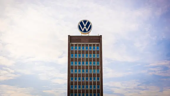 Das Volkswagen-Logo steht auf dem Dach vom Markenhochhaus in Wolfsburg. | picture alliance/dpa | Moritz Frankenberg, Moritz Frankenberg Das Volkswagen-Logo steht auf dem Dach vom Markenhochhaus in Wolfsburg.