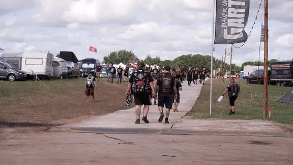 Gut ein Drittel der Besucherinnen und Besucher ist laut Veranstalter schon in Wacken angekommen. | NDR / Dominik Dührsen Viele Menschen laufen über das Gelände vom Wacken-Festival.