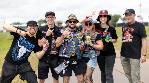 Besucher des Wacken Open Air posieren für ein Gruppenbild | NDR, Alexander Mühlhausen Besucher des Wacken Open Air posieren für ein Gruppenbild