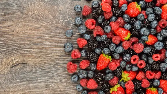 Verschiedene Beeren liegen auf einem Holztisch. | Colourbox, Olga Vasilyeva Verschiedene Beeren liegen auf einem Holztisch.