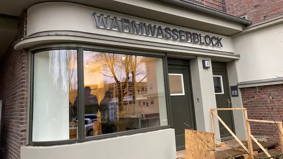 Auf einem Gebäude steht die Aufschrift "Warmwasserblock". | NDR, Reinhard Postelt Auf einem Gebäude steht die Aufschrift "Warmwasserblock".