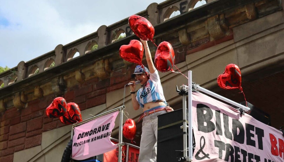Politische Kundgebung mit roten Ballons und Transparenten vor einem historischen Gebäude