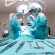 OP-Besteck liegt während einer Operation bereit, im Hintergrund operieren mehrere Menschen unter einer Leuchte. OP-Besteck liegt während einer Operation bereit, im Hintergrund operieren mehrere Menschen unter einer Leuchte.