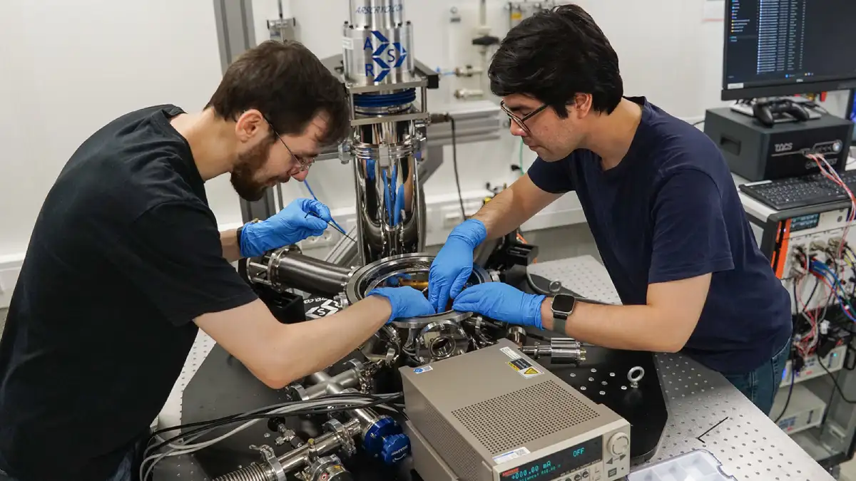 David Walther (l.) und Carlos Rincon, Wissenschaftliche Mitarbeiter der Professur Werkstoffe und Zuverlässigkeit mikrotechnischer Systeme der TU Chemnitz, installieren einen neuen Teststand in der Kammer eines Helium-Kryostaten.  Foto: Uwe Zschenderlein für die TUC