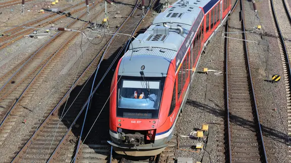 Wegen Bauarbeiten gibt es in den kommenden Wochen zwischen Hamburg und Lübeck sowie Hamburg und Flensburg immer wieder Sperrungen und Zugausfälle. | NDR, Pavel Stoyan Ein Zug der Regionalbahn fährt bei sonnigem Wetter. Das Bild wurde von Oben auf die Gleise fotografiert.