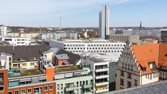 Ausblick vom Hohen Turm der Jakobikirche auf die Innenstadt, bunter Schornstein vom Heizkraftwerk Nord und Hochhaus vom Kongresshotel mit Stadthalle | IMAGO / Hanke Ausblick vom Hohen Turm der Jakobikirche auf die Innenstadt, bunter Schornstein vom Heizkraftwerk Nord und Hochhaus vom Kongresshotel mit Stadthalle