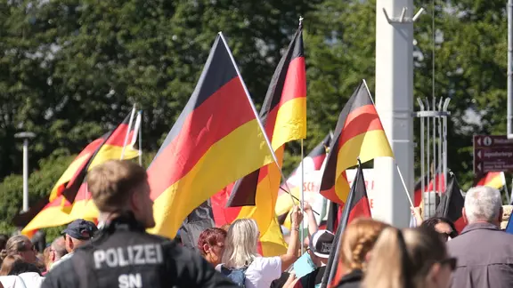 Zwölf Versammlungen und Autokorsos waren für Sonnabend in Plauen angemeldet. | picture alliance/dpa | Sebastian Willnow Polizisten überwachen eine Demonstration