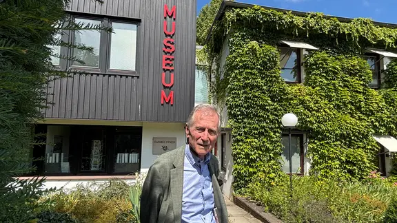 Ein lächelnder, älterer Herr vor dem Bargheer Museum, Leiter Dirk Justus. 