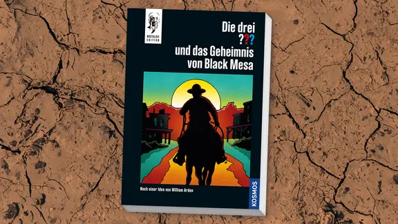 Auf dem Buchcover von "Die drei ??? und das Geheimnis von Black Mesa" reitet ein Cowboy in den Sonnenuntergang. | Kosmos Verlag Auf dem Buchcover von "Die drei ??? und das Geheimnis von Black Mesa" reitet ein Cowboy in den Sonnenuntergang.