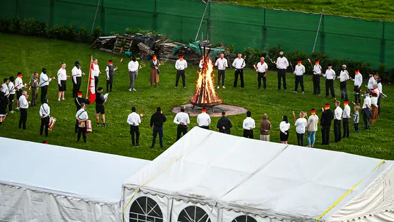 Menschen stehen in Eschede im Landkreis Celle mit Fackeln und Trommeln in einem Kreis um eine brennende Rune aus Holz. | Recherche Nord Menschen stehen in Eschede im Landkreis Celle mit Fackeln und Trommeln in einem Kreis um eine brennende Rune aus Holz.