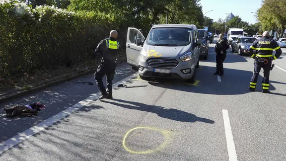 Polizisten untersuchen die Straße, auf der es einen tödlichen Fahrradunfall gab. | picture alliance Polizisten untersuchen die Straße, auf der es einen tödlichen Fahrradunfall gab.