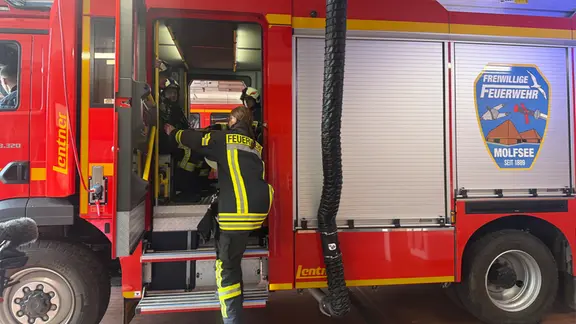 Mitte Juli probt die Freiwillige Feuerwehr Molfsee einen Einsatz - der NDR begleitet die Aktion. Dabei geht es vorwiegend um die Einhaltung der Hilfsfrist. | NDR / Robert Bittig Einsatzkräfte der Feuerwehr steigen in ein Fahrzeug ein.