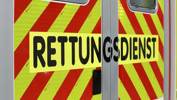 Schriftzug "Rettungsdienst" steht auf einem gelb-rot gestreiften Einsatzfahrzeug. | NDR, Pavel Stoyan Schriftzug "Rettungsdienst" steht auf einem gelb-rot gestreiften Einsatzfahrzeug.