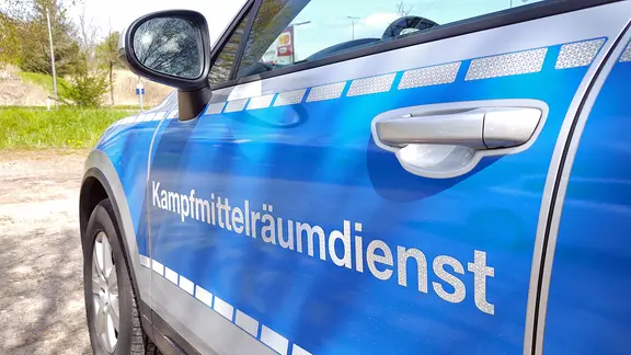 Während einer Bombenevakuierung in Flensburg steht ein Wagen mit der Tür-Aufschrift Kampfmittelräumdienst am Straßenrand. | NDR, Peer-Axel Kroeske Während einer Bombenevakuierung in Flensburg steht ein Wagen mit der Tür-Aufschrift Kampfmittelräumdienst am Straßenrand.