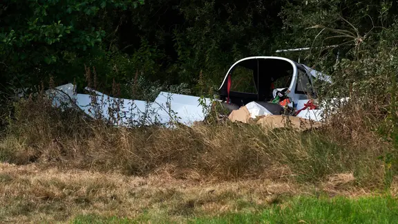 Kurz nach dem Start stürzte das Flugzeug ab. Aus den Trümmern am Waldrand konnte der Pilot nur noch tot geborgen werden. | Marcus Golejewski Teile eines kleinen Flugzeuges hinter hohen Gräsern