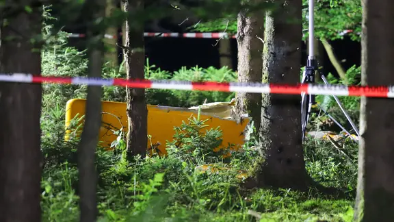 In einem Waldstück liegt ein Teil eines Flugzeugs, abgesperrt mit Flatterband. | ndr, Florian Sprenger In einem Waldstück liegt ein Teil eines Flugzeugs, abgesperrt mit Flatterband.