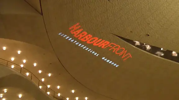 Die Aufschrift Harbour Front Literaturfestival projiziert auf die Wand im Großen Saal der Elbphilharmonie Hamburg | NDR Screenshot Die Aufschrift Harbour Front Literaturfestival projiziert auf die Wand im Großen Saal der Elbphilharmonie Hamburg