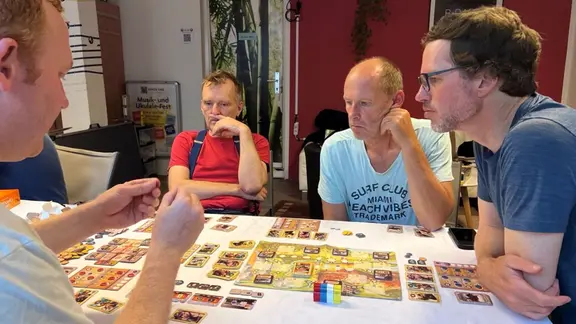 Brettspielabend im Winterquartier der "MINNA" in der Boizenburger Altstadt. | NDR, Lucie Kluth Vier Männer sitzen am Tisch und spielen.