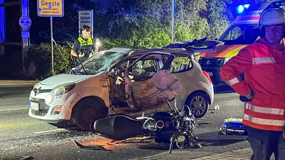 Bei dem Zusammenstoß wurde ein 20-Jähriger tödlich verletzt. | Nord-West-Media TV/dpa, Marco Schlösser Rettungskräfte an einer Unfallstelle in Geeste; ein zerstörtes Auto und Motorrad auf der Straße