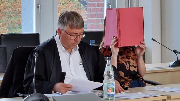Die Angeklagte Gina H. im Gerichtssaal neben einem ihrer Verteidiger. | NDR, Andreas Frost Die Angeklagte Gina H. im Gerichtssaal neben einem ihrer Verteidiger.