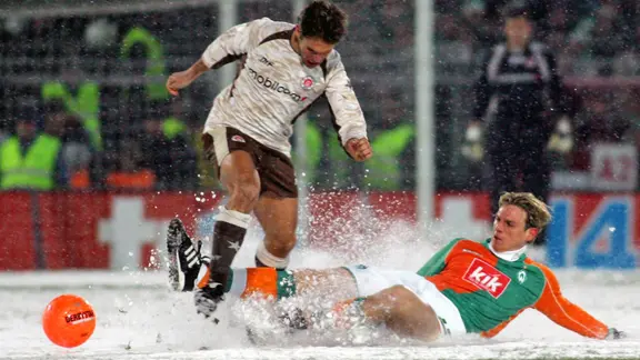 Werder Bremens Tim Borowski (r.) grätscht gegen St. Paulis Florian Lechner im Pokal-Duell 2006.