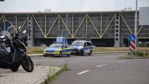 Einsatzfahrzeuge der Polizei stehen am Flughafen Leipzig/Halle. | Tobias Junghanns/dpa Einsatzfahrzeuge der Polizei stehen am Flughafen Leipzig/Halle.