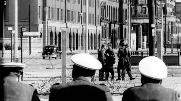 West-Berliner Polizisten schauen im August 1961 auf den Grenzzaun am Potsdamer Platz. | IMAGO / Sabine Gudath West-Berliner Polizisten schauen im Sommer 1961 auf den Grenzzaun am Potsdamer Platz.