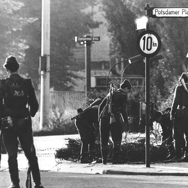Volkspolizisten beim Errichten von Stacheldrahtsperren am Potsdamer Platz. | picture-alliance / dpa | Giehr Volkspolizisten beim Errichten von Stacheldrahtsperren am Potsdamer Platz.