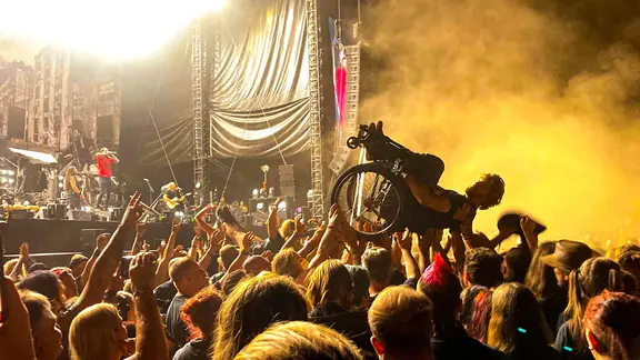 Das Reload-Festival lockt Fans härterer Musik in die niedersächsische Provinz nach Sulingen. (Archivbild) | NDR, Sven Glagow Ein Mann samt Rollstuhl beim Crowdsurfing. (Es spielt die Band "Heaven Shall Burn" beim Reload-Festival in Sulingen.)