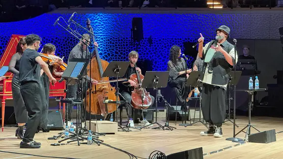 Samy Deluxe steht mit dem Takeover Ensemble auf der Bühne der Elbphilharmonie | NDR.de, Kai Salander Samy Deluxe steht mit dem Takeover Ensemble auf der Bühne der Elbphilharmonie